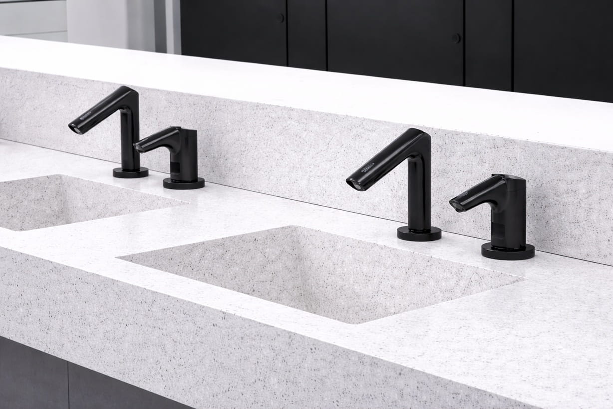 High traffic airport public restroom with multiple touchless faucets along a wide sink counter